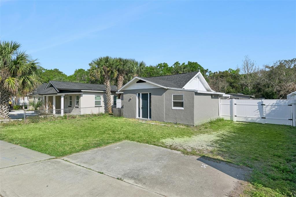 A view of two small, gray, single-story houses with dark roofs and a concrete driveway — 5419 OLD CHENEY HIGHWAY, ORLANDO, FL