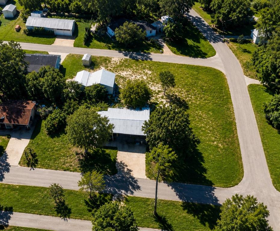 An aerial view shows a residential property with a metal-roofed house and detached garage — NW 177TH PLACE, HIGH SPRINGS, FL