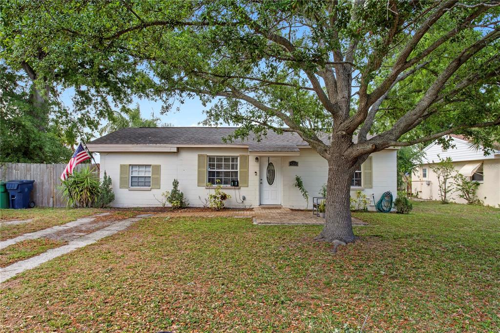 A single-story house with a white exterior, tan shutters, and a large tree in front — 4215 W BAY VISTA AVENUE, TAMPA, FL