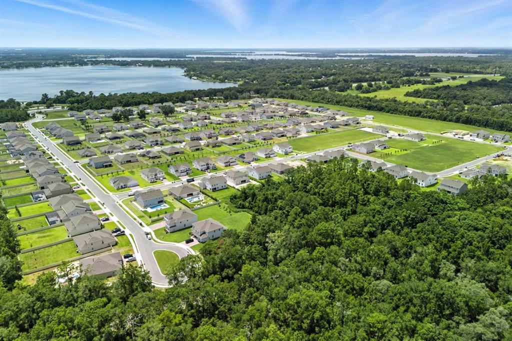 A two-story light blue house with a two-car garage and a landscaped front yard — 5079 NORTHERN DOVE AVENUE, MOUNT DORA, FL