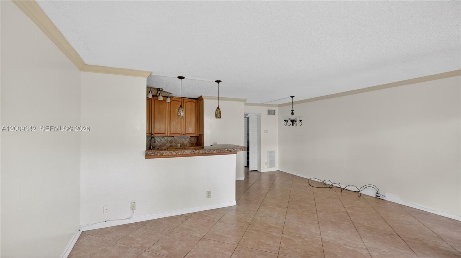 An open-concept living and dining area features tile flooring and a kitchen breakfast bar — 48 Mansfield B # 48, Boca Raton FL 33434, BOCA RATON, FL