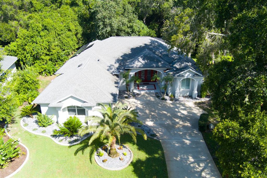 An aerial view of a single-story house with a gray roof, driveway, and landscaping — 1321 WICKLOW LANE, ORMOND BEACH, FL