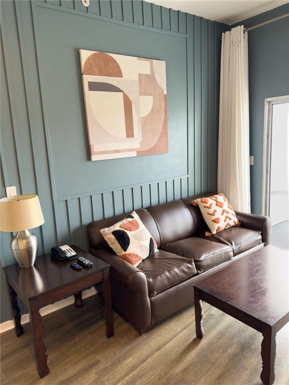 A living room features a brown leather sofa, a side table with a lamp, and artwork — 225 CELEBRATION PLACE UNIT # 527, KISSIMMEE, FL