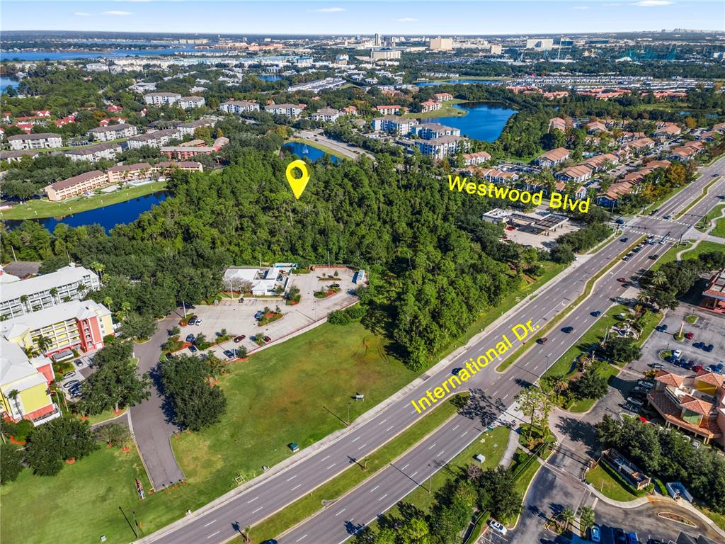 An aerial view shows a wooded lot located between International Drive and Westwood Boulevard — 11990 INTERNATIONAL DRIVE, ORLANDO, FL