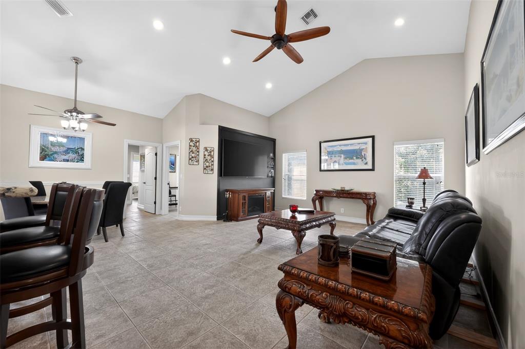 A living room features vaulted ceilings, tile flooring, a black media wall, and leather furniture — 12301 CABOT COURT, BOCA RATON, FL