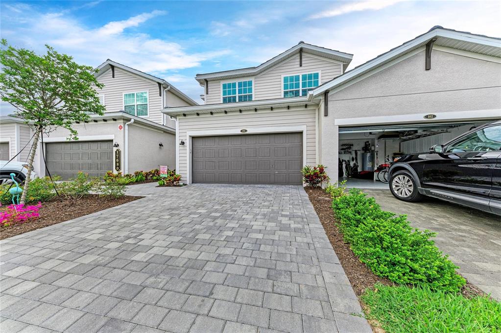 The exterior of two attached suburban homes features paved driveways and a parked black SUV — 17680 BORACAY COURT UNIT 202, VENICE, FL