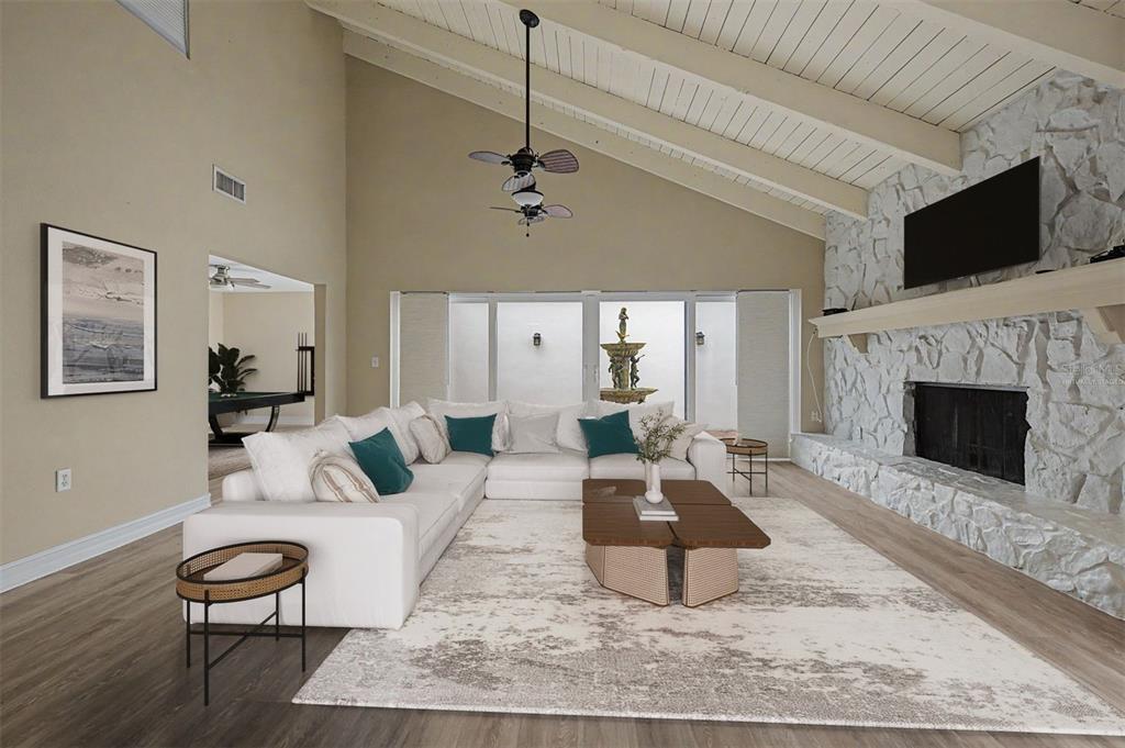 A living room features a white sectional sofa, a stone fireplace, and a vaulted ceiling — 360 S WOODLANDS DRIVE, OLDSMAR, FL