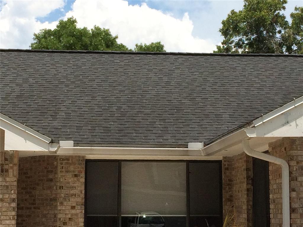 The exterior of a brick house features a dark shingled roof and white gutters — 1114 SEAFARER LANE, WINTER SPRINGS, FL