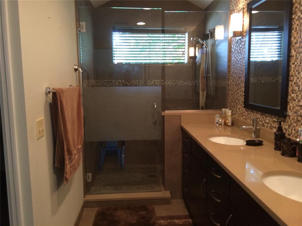 A bathroom features a double vanity with dark cabinets, a glass-enclosed shower, and mosaic tile — 1114 SEAFARER LANE, WINTER SPRINGS, FL