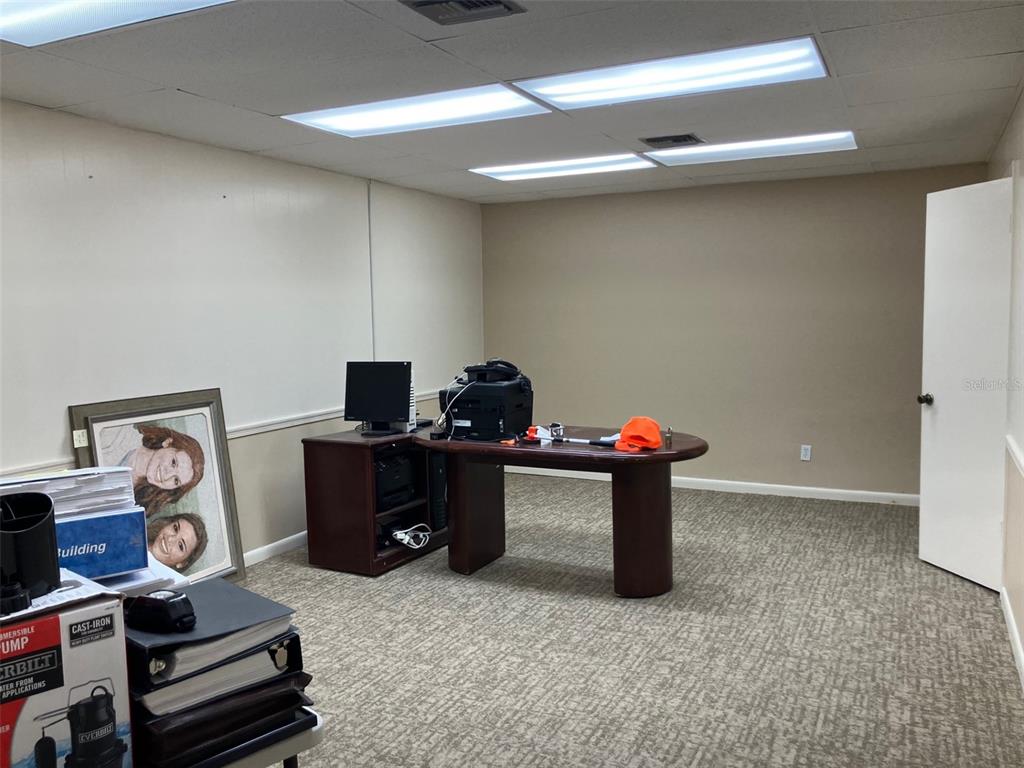 An office room features a dark wood desk, carpeted flooring, and recessed ceiling lights — 4233 W EL PRADO BOULEVARD, TAMPA, FL