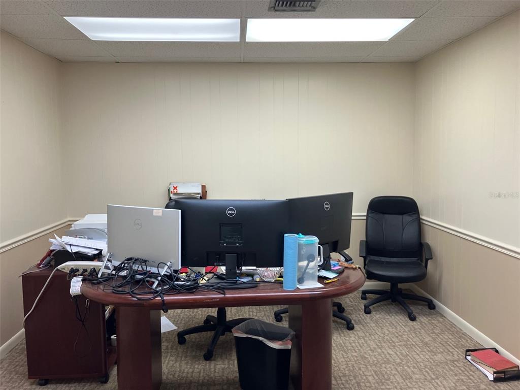 A home office features a large wooden desk, two computer monitors, and a black chair — 4233 W EL PRADO BOULEVARD, TAMPA, FL