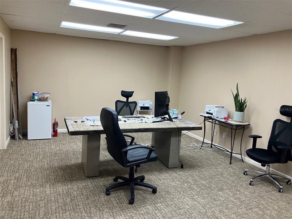 An office space features a large wooden desk, two rolling chairs, and beige walls — 4233 W EL PRADO BOULEVARD, TAMPA, FL