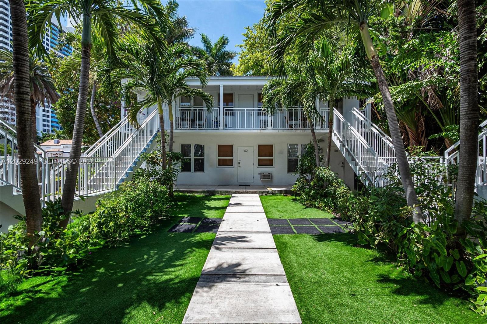 A two-story white apartment building features exterior staircases and a central concrete walkway — 1419 West Ave # 201, Miami Beach FL 33139, MIAMI BEACH, FL