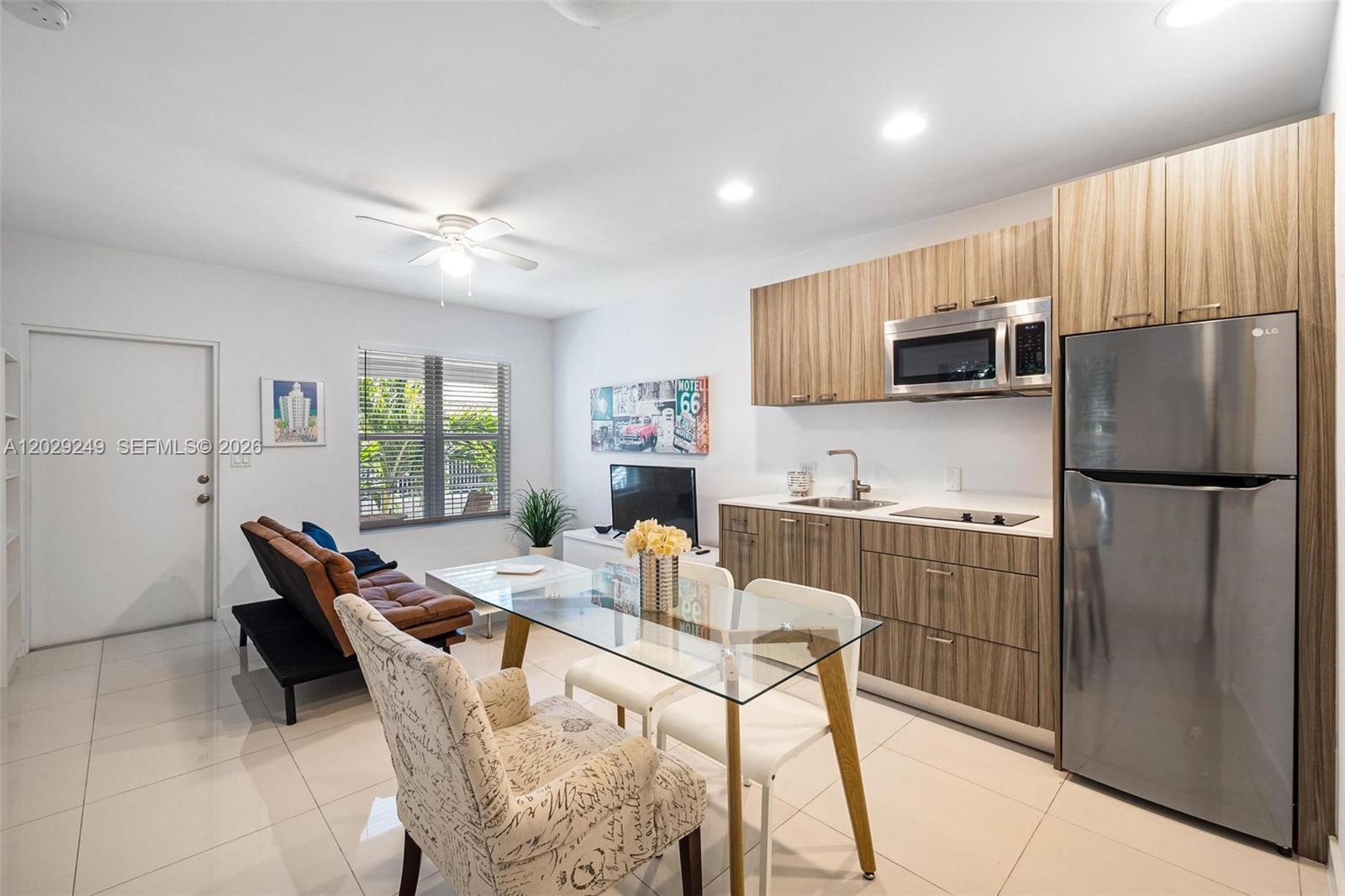 A small apartment features a kitchen with wood cabinets, a dining area, and a sofa — 1419 West Ave # 201, Miami Beach FL 33139, MIAMI BEACH, FL