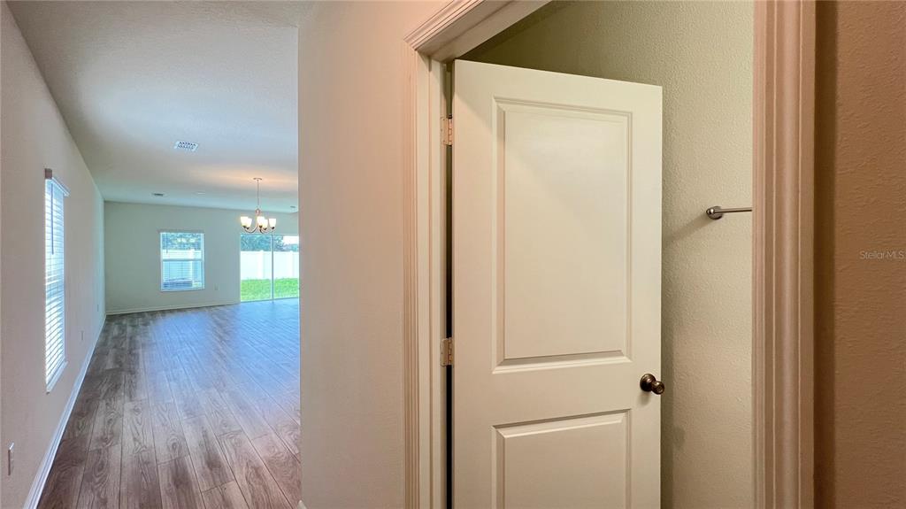 A white door opens into a small closet, revealing a view of a living area — 1340 MIRABELLA CIRCLE, DAVENPORT, FL