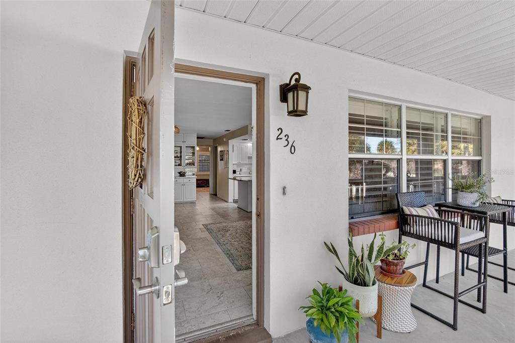 A front porch with a door opening into a tiled interior living space — 650 PINELLAS POINT DRIVE S UNIT 236, ST PETERSBURG, FL