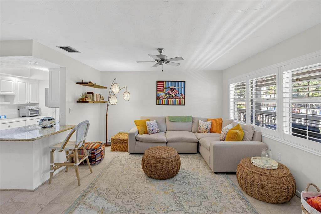 A living room with a sectional sofa, area rug, and an adjacent kitchen breakfast bar — 650 PINELLAS POINT DRIVE S UNIT 236, ST PETERSBURG, FL