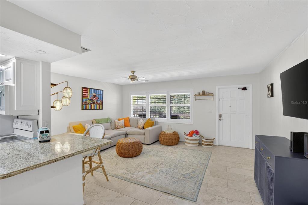 A living room features a sectional sofa, a patterned rug, and a kitchen island — 650 PINELLAS POINT DRIVE S UNIT 236, ST PETERSBURG, FL