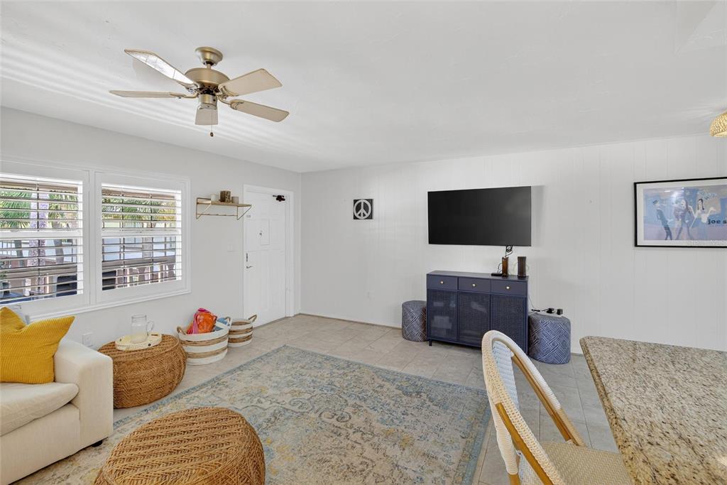A living room features a ceiling fan, a wall-mounted television, and a blue media console — 650 PINELLAS POINT DRIVE S UNIT 236, ST PETERSBURG, FL