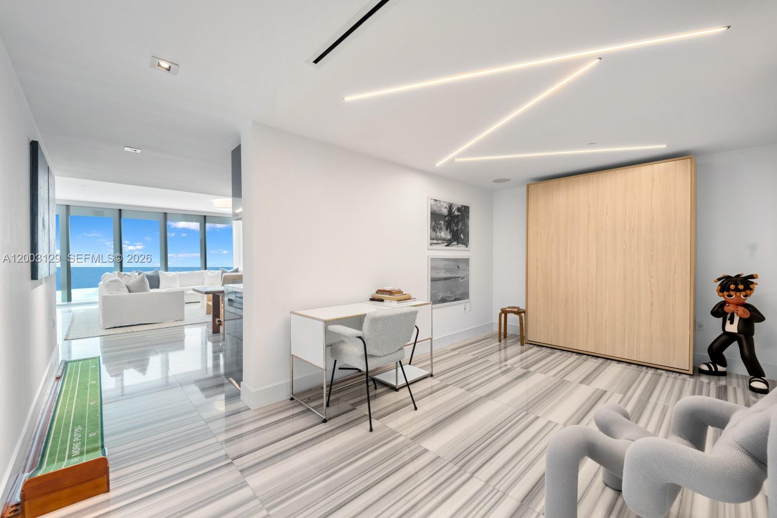 A modern room features a desk, a large wooden cabinet, and a putting green mat — 1451 Brickell Ave # 903, Miami FL 33131, MIAMI, FL