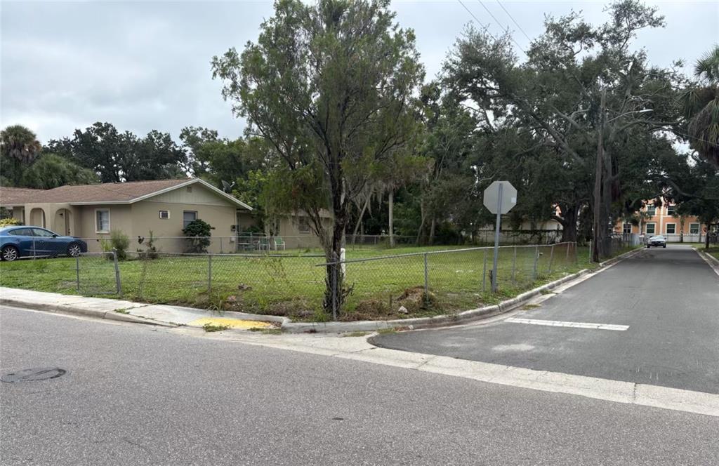 A corner lot with a chain-link fence, a small house, and mature trees — 1626 22ND STREET, SARASOTA, FL