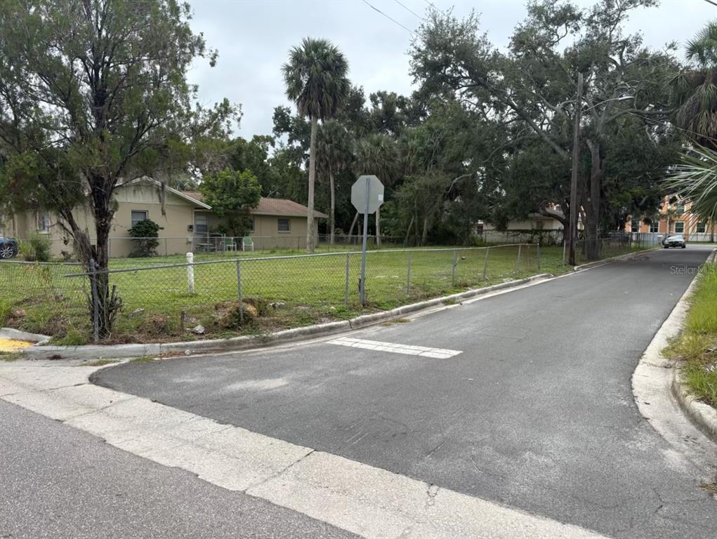 A fenced, grassy corner lot with a house and trees under an overcast sky — 1626 22ND STREET, SARASOTA, FL