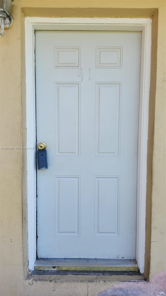 A white six-panel door with a lockbox is set into a beige exterior wall — 2651 NW 13th St # 41, Miami FL 33125, MIAMI, FL