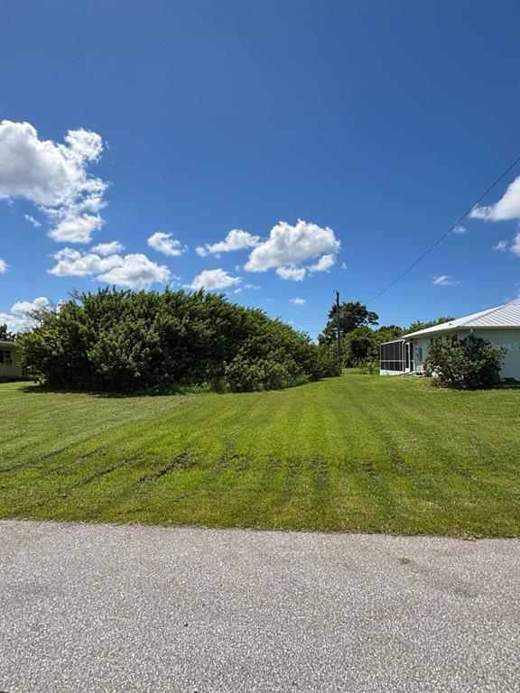 A grassy vacant lot sits next to a house with a screened-in porch — 193 GARDEN AVENUE NW, PORT CHARLOTTE, FL