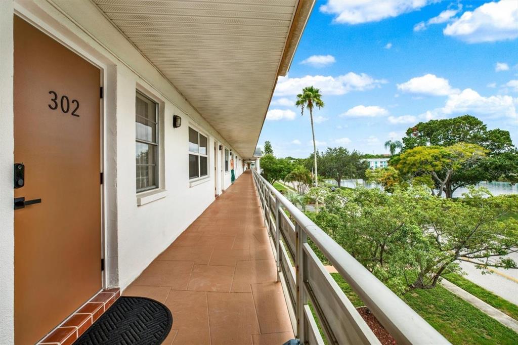 A living room and dining area with a dark green sofa, round table, and ceiling fan — 6015 19TH STREET N UNIT 302, ST PETERSBURG, FL