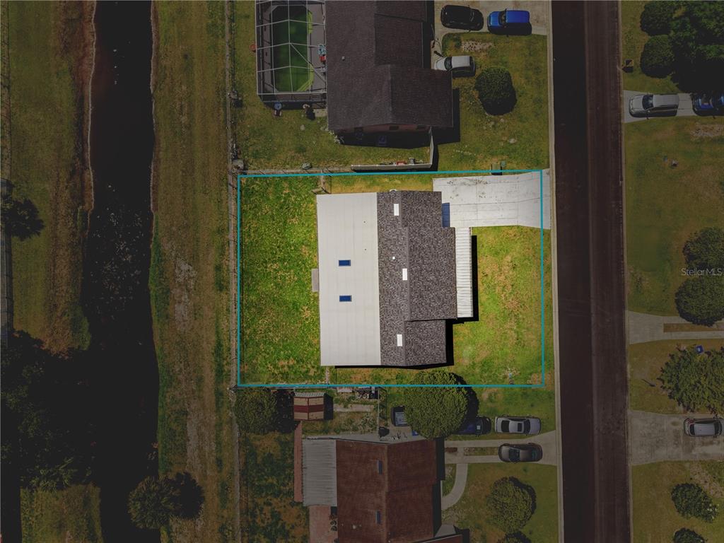 An aerial view shows a house with a gray roof and a fenced backyard — 103 LUCA LANE, KISSIMMEE, FL