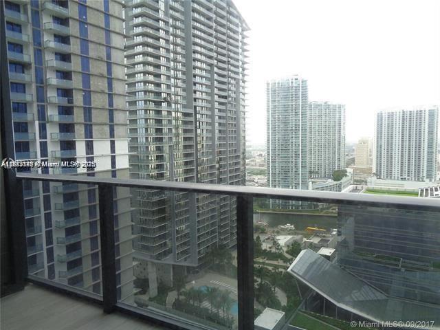 A high-rise balcony overlooks a city skyline with multiple glass skyscrapers and a small pool — 45 SW 9th St # 2709, Miami FL 33130, MIAMI, FL