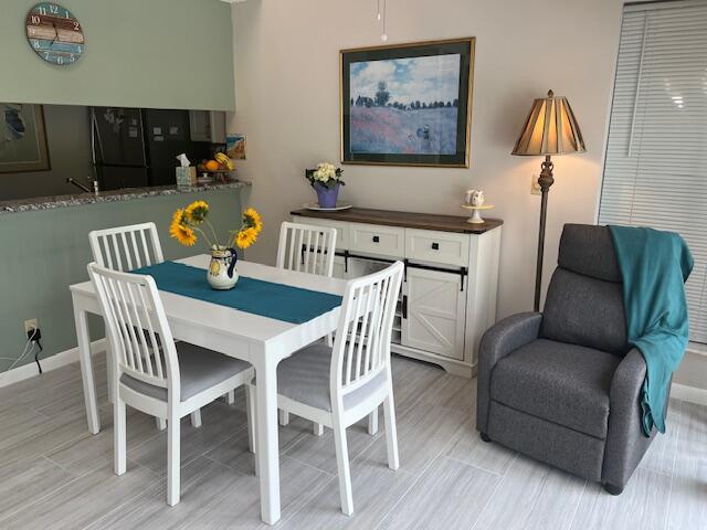A dining area features a white table, four chairs, a sideboard, and a gray recliner — 1605 S Us Highway 1, Jupiter FL 33477, JUPITER, FL