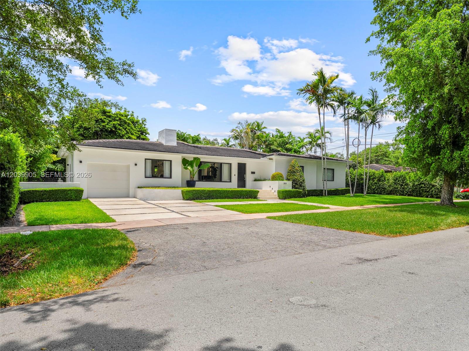 A single-story white house with a paved driveway, manicured lawn, and palm trees — 511 Perugia Ave, Coral Gables FL 33146, CORAL GABLES, FL
