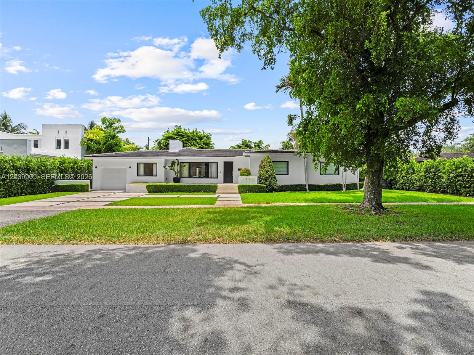 A single-story white house with a garage and a large tree in the front yard — 511 Perugia Ave, Coral Gables FL 33146, CORAL GABLES, FL
