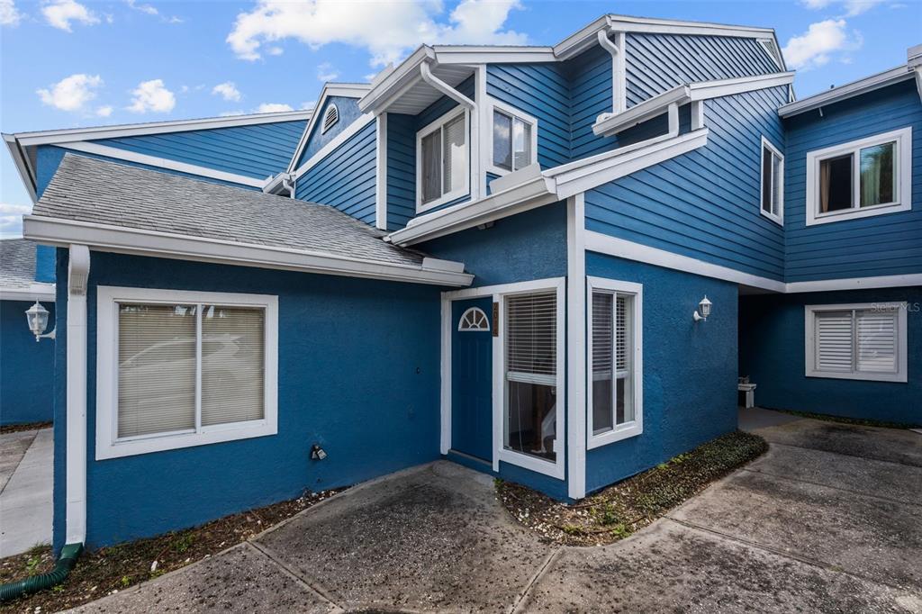 A two-story blue house with white trim and a concrete patio entrance — 2014 GOLFVIEW DRIVE UNIT 2014, TARPON SPRINGS, FL