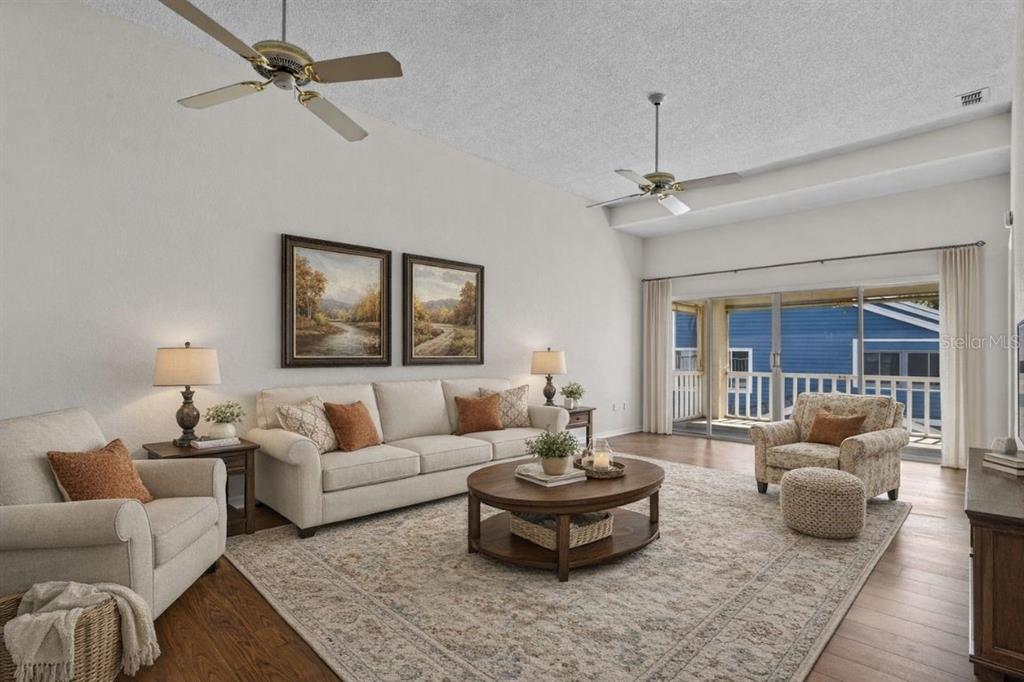 A living room features a beige sofa, two armchairs, a coffee table, and ceiling fans — 2014 GOLFVIEW DRIVE UNIT 2014, TARPON SPRINGS, FL