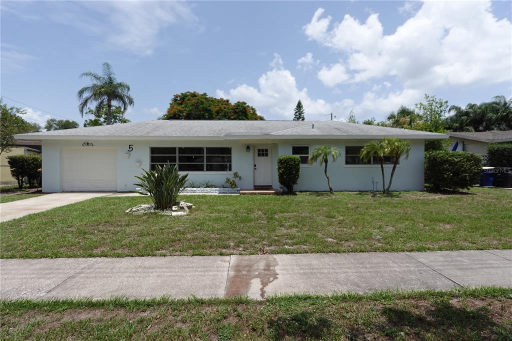 A single-story house with a white exterior, a front garage, and a grassy lawn — 5 S HERCULES AVENUE, CLEARWATER, FL