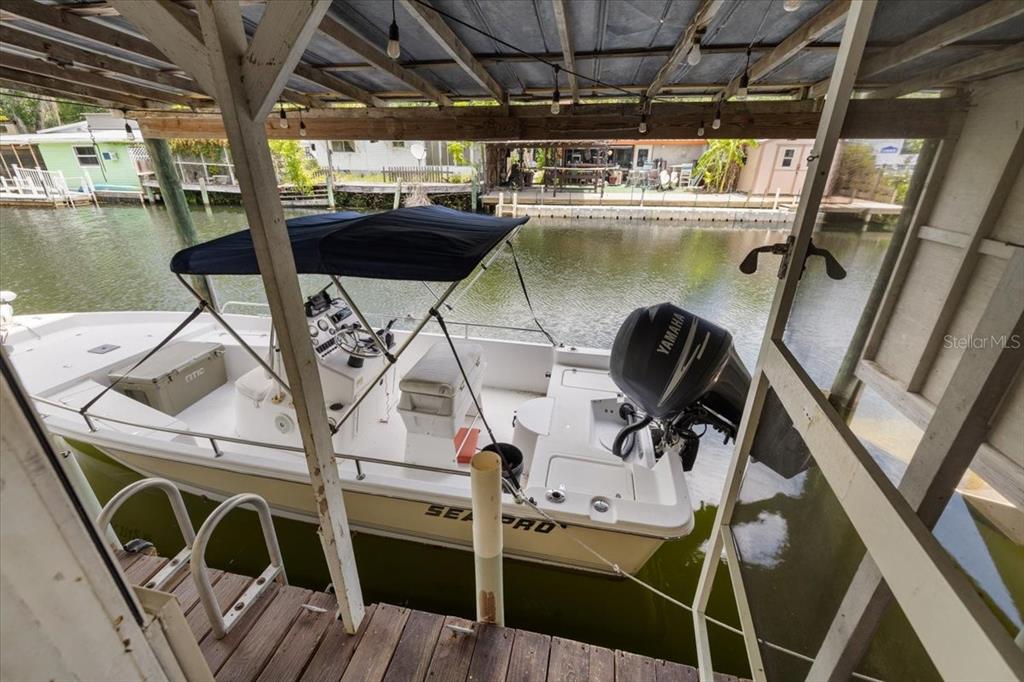 A white Sea Pro boat with a Yamaha motor is docked under a covered slip — 7264 ABERDEEN COURT, WEEKI WACHEE, FL