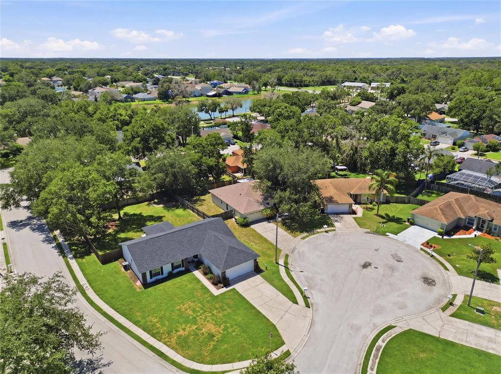 An aerial view shows a suburban neighborhood with single-family homes, driveways, and mature trees — 2614 SUNDANCE COURT, MULBERRY, FL