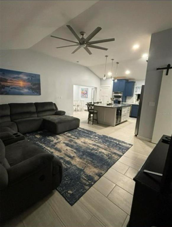 A living room with a dark sectional sofa, area rug, and open kitchen with island — 177 IROQUOIS STREET, TAVERNIER, FL