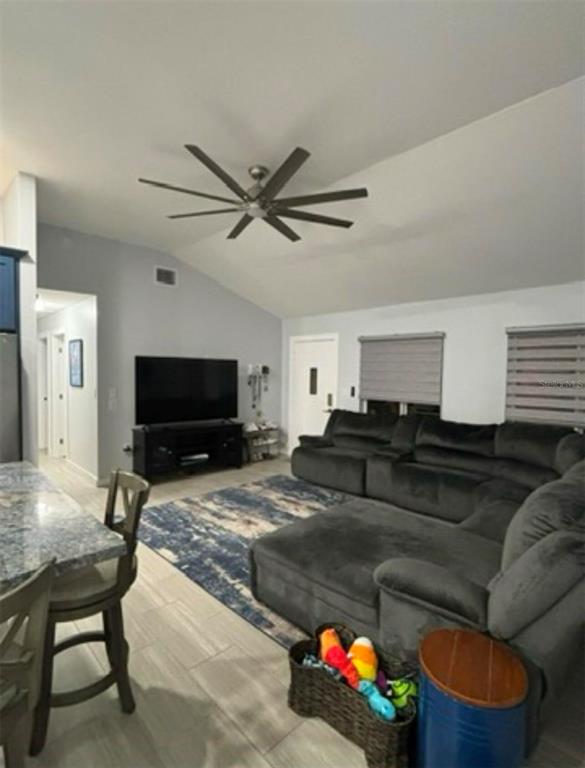 A living room features a large gray sectional sofa, a television on a stand, and tile flooring — 177 IROQUOIS STREET, TAVERNIER, FL
