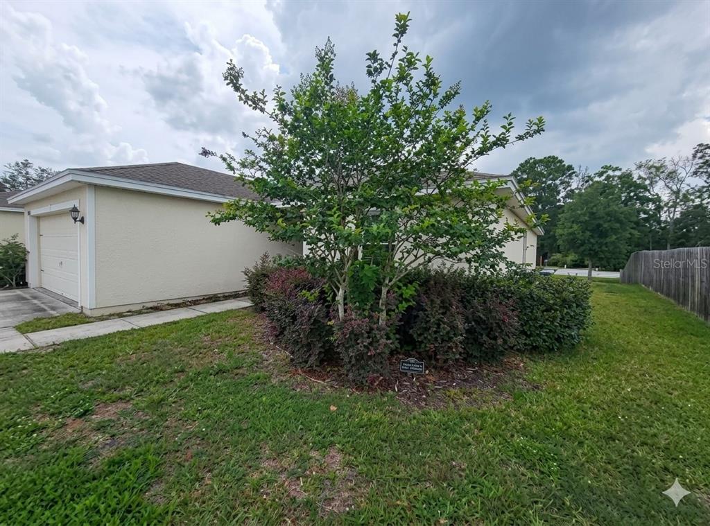 A single-story house with a two-car garage, solar panels, and a concrete driveway — 8650 LAKE GEORGE CIRCLE W, MACCLENNY, FL