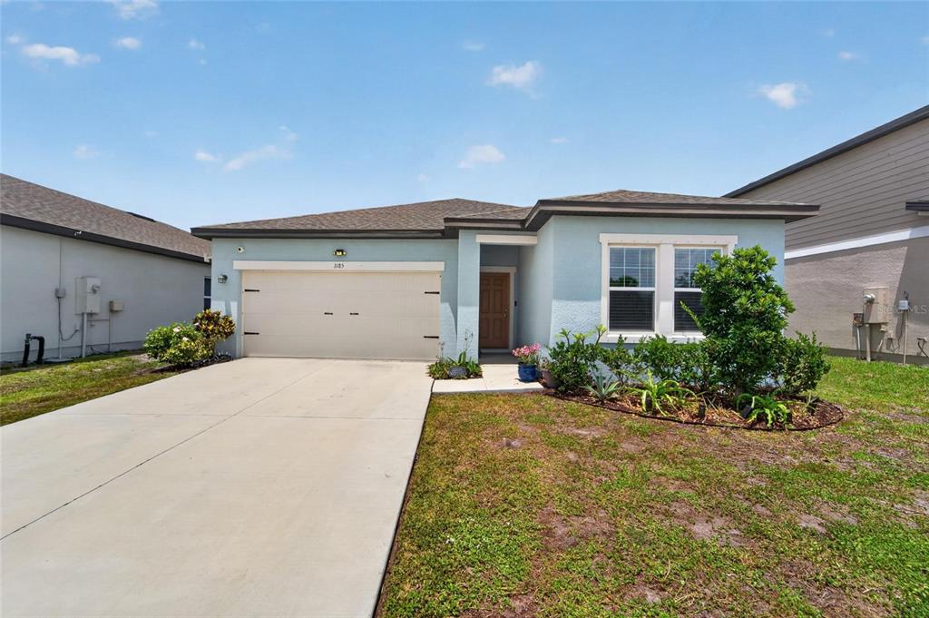 A light blue single-story house features a two-car garage and a front yard — 1185 ANCHOR BEND DRIVE, RUSKIN, FL