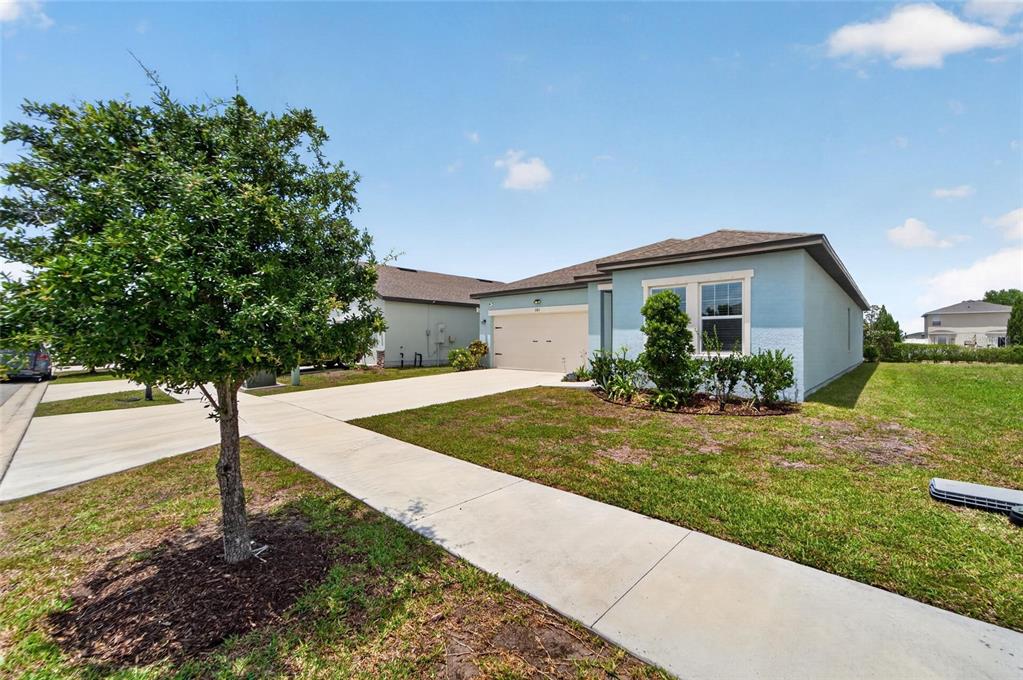 A light blue single-story house with a tan garage and a front yard with a tree — 1185 ANCHOR BEND DRIVE, RUSKIN, FL