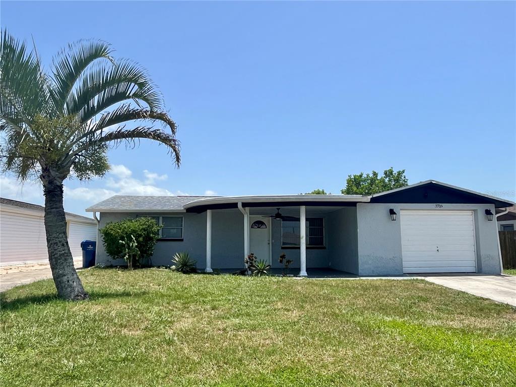 A single-story house with a gray exterior, a front porch, and an attached garage — 3716 CEDARWOOD DRIVE, HOLIDAY, FL