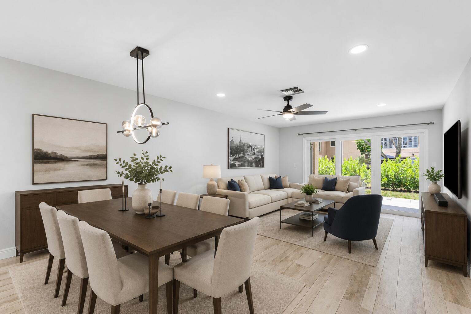 An open-concept living and dining area features light wood floors, neutral furniture, and sliding doors — 13788 Via Flora # B, Delray Beach FL 33484, DELRAY BEACH, FL