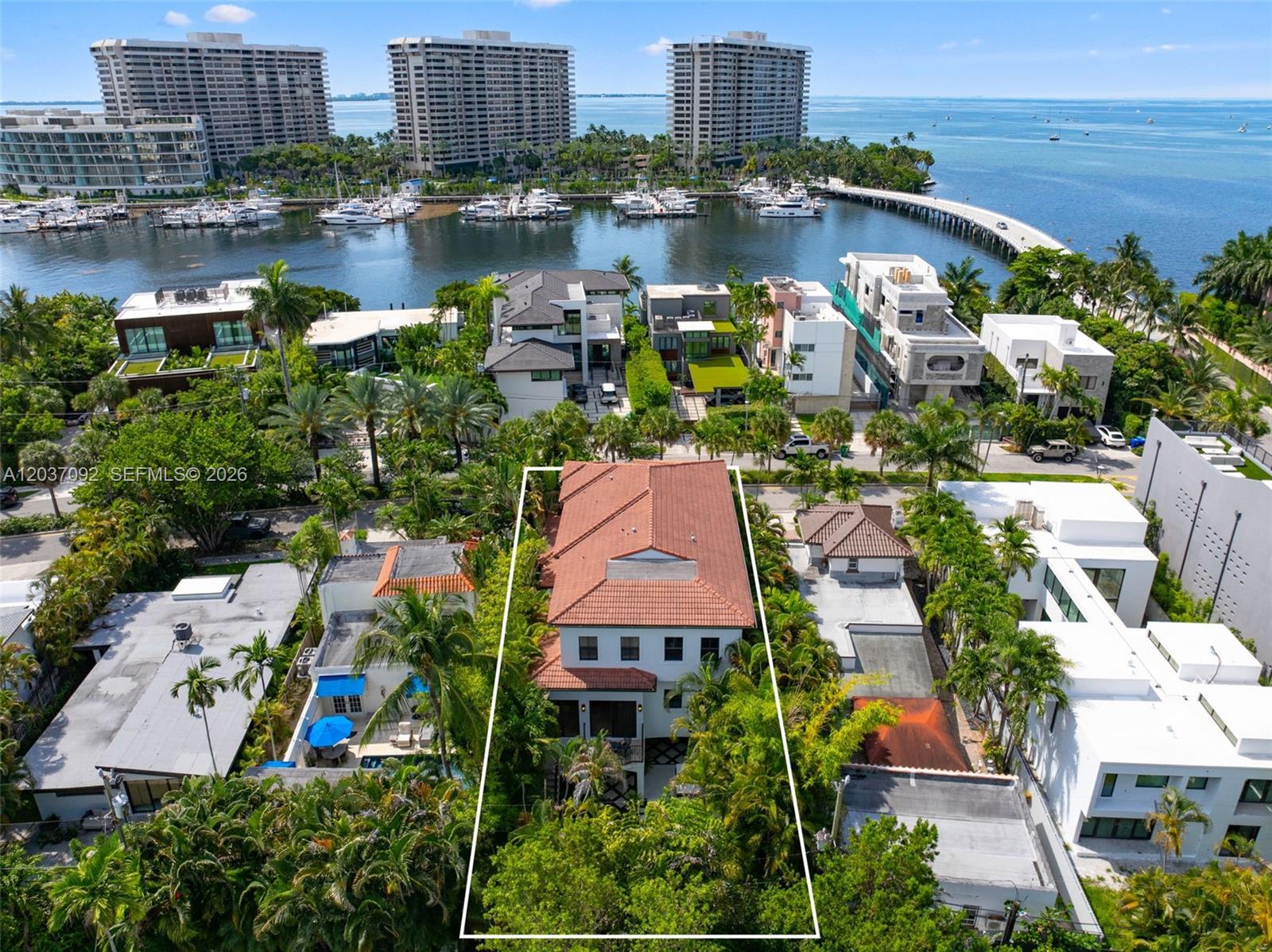 An aerial view shows a multi-story house with a red tile roof and lush landscaping — 1803 S Bayshore Ln, Miami FL 33133, MIAMI, FL
