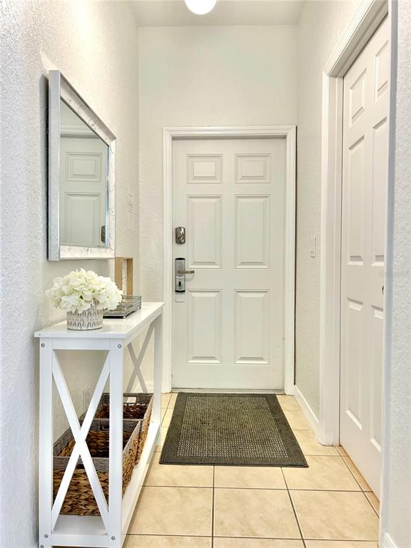 An entryway features a white console table, a mirror, and a door with a tiled floor — 616 VERONA AVE, DAVENPORT, FL