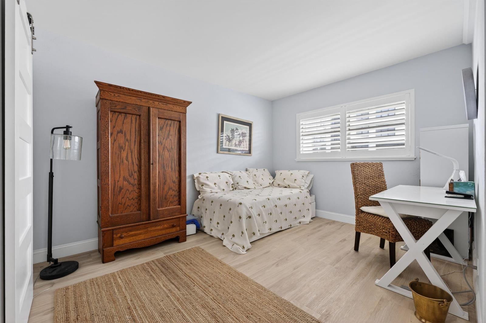 A bedroom features light wood flooring, a wooden armoire, a daybed, and a white desk — 3101 S Ocean Boulevard # 302, Highland Beach FL 33487, HIGHLAND BEACH, FL