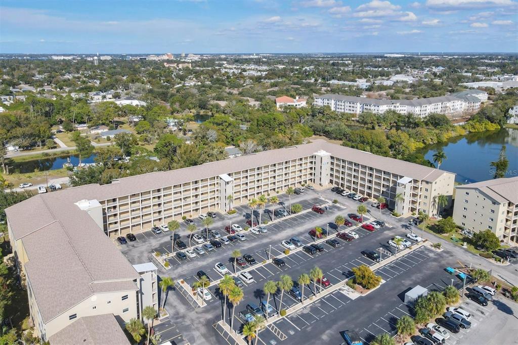 An aerial view shows a large multi-story apartment complex with a central parking lot — 3534 LAKE BAYSHORE DRIVE UNIT K118, BRADENTON, FL